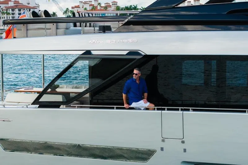 Slide: The Image of Man on a 2022 Riva 90' Argo yacht, docked by waterfront buildings. - 46