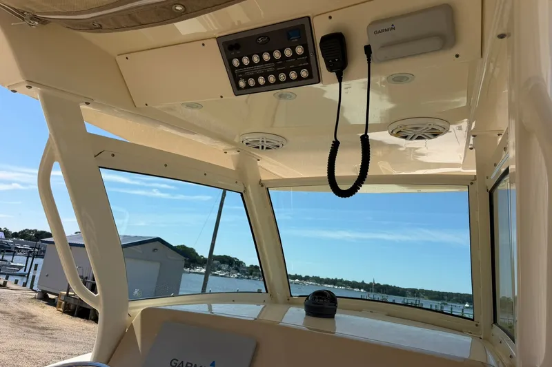 Slide: The Image of Interior view of 2019 Scout 300 LXF boat with Garmin equipment and scenic marina backdrop. - 18