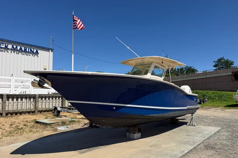 Slide: The Image of 2019 Scout 300 LXF boat on display at marina with American flag. - 3