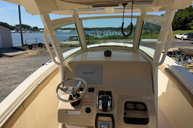 Slide: The Image of 2019 Scout 300 LXF boat cockpit with Garmin navigation, overlooking serene waterfront. - 19