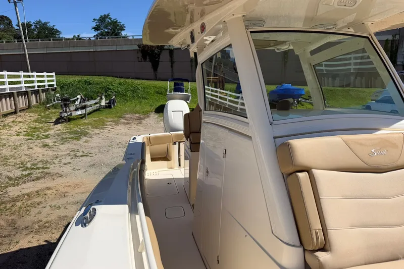 Slide: The Image of 2019 Scout 300 LXF boat with beige seating, docked outdoors. - 8