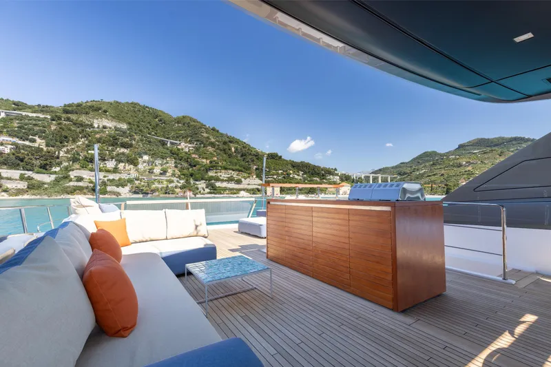 Slide: The Image of Luxurious Sanlorenzo SL106A yacht deck with seating, grill, and scenic coastal view. - 33