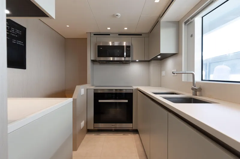 Slide: The Image of Modern kitchen interior on 2022 Sanlorenzo SL106A yacht, featuring sleek cabinetry and appliances. - 26