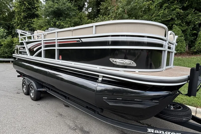Slide: The Image of 2023 Ranger 223C pontoon boat on trailer, parked outdoors. - 16