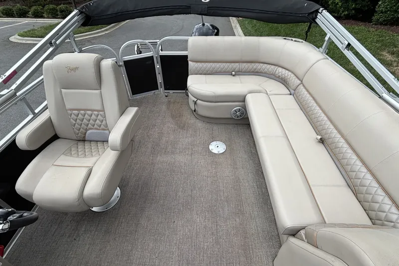 Slide: The Image of 2023 Ranger 223C boat interior with beige seating and carpeted floor. - 22