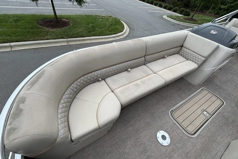 Slide: The Image of 2023 Ranger 223C boat interior with beige cushioned seating and carpeted flooring. - 17