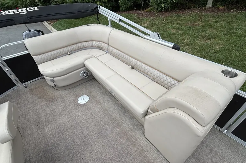Slide: The Image of 2023 Ranger 223C boat interior with beige seating and cup holder. - 21