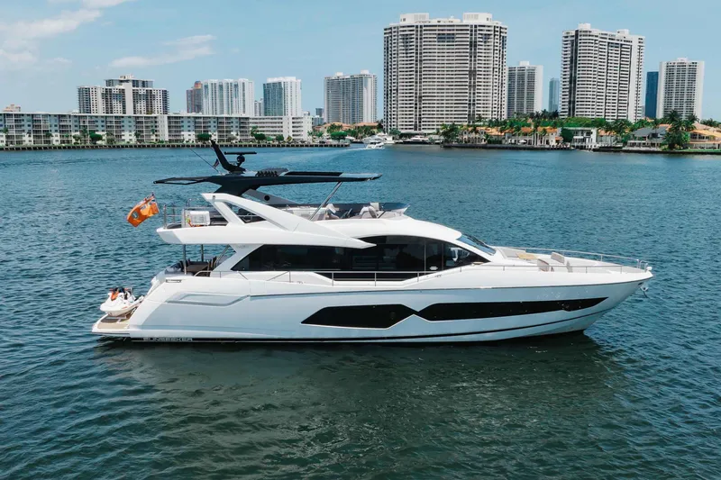The Image of 2022 Sunseeker 76 Yacht cruising near urban skyline, showcasing luxury and modern design. - 0