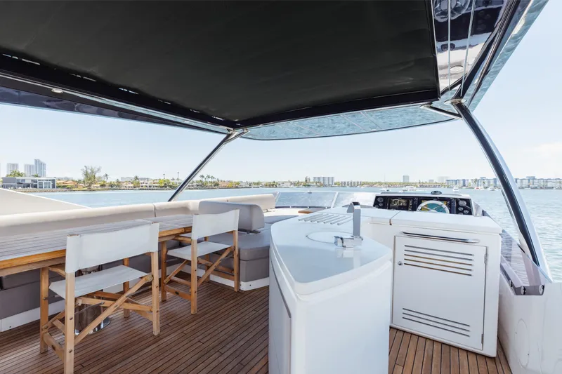 Slide: The Image of Luxurious 2022 Sunseeker 76 Yacht deck with seating and scenic waterfront view. - 78