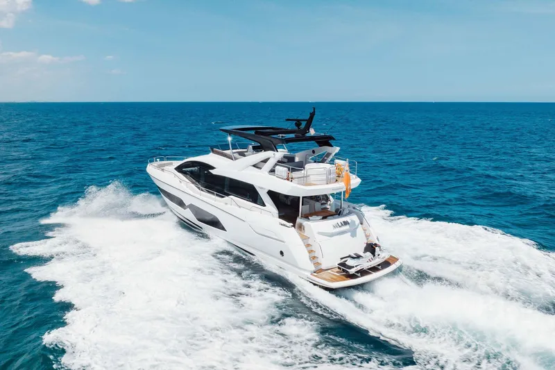 Slide: The Image of 2022 Sunseeker 76 Yacht cruising on open sea under clear blue sky. - 26