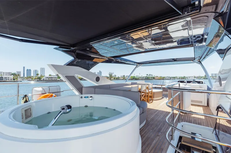 Slide: The Image of Luxurious 2022 Sunseeker 76 Yacht deck with jacuzzi and seating area, overlooking waterfront skyline. - 71