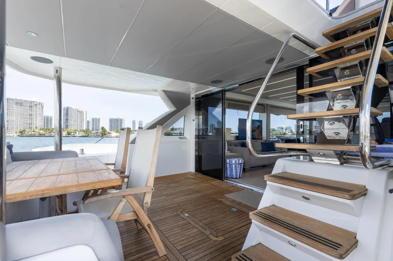 Slide: The Image of Luxurious 2022 Sunseeker 76 Yacht deck with wooden table, chairs, and modern staircase. - 31