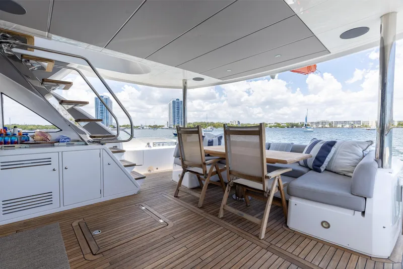 Slide: The Image of Luxurious 2022 Sunseeker 76 Yacht deck with seating, table, and scenic waterfront view. - 30