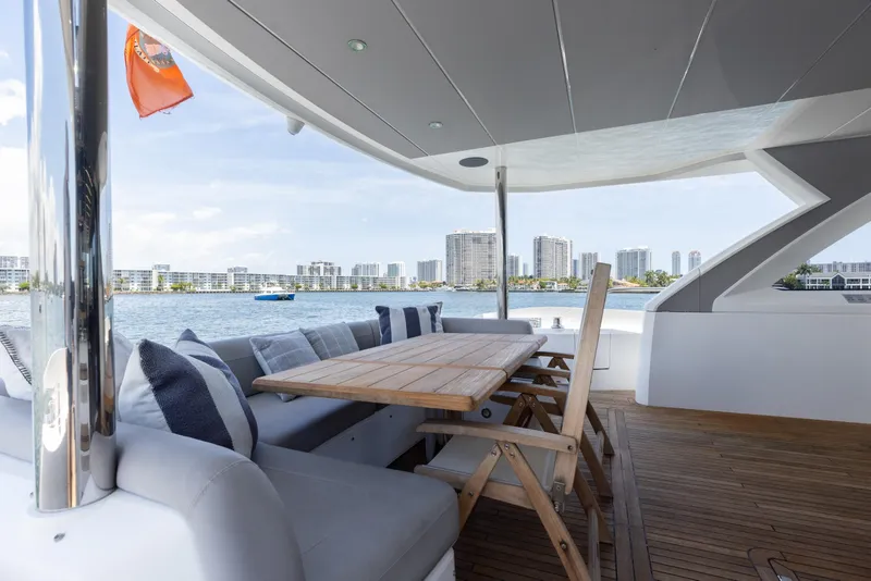 Slide: The Image of Luxurious Sunseeker 76 Yacht 2022 with elegant outdoor seating and scenic waterfront view. - 28