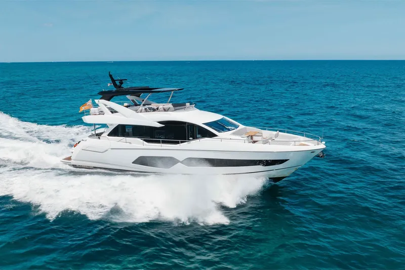 Slide: The Image of 2022 Sunseeker 76 Yacht cruising on open blue sea under clear sky. - 21