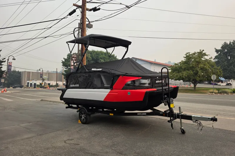 Slide: The Image of 2024 Seadoo Switch Sport boat on trailer, parked on street, covered and ready for transport. - 3