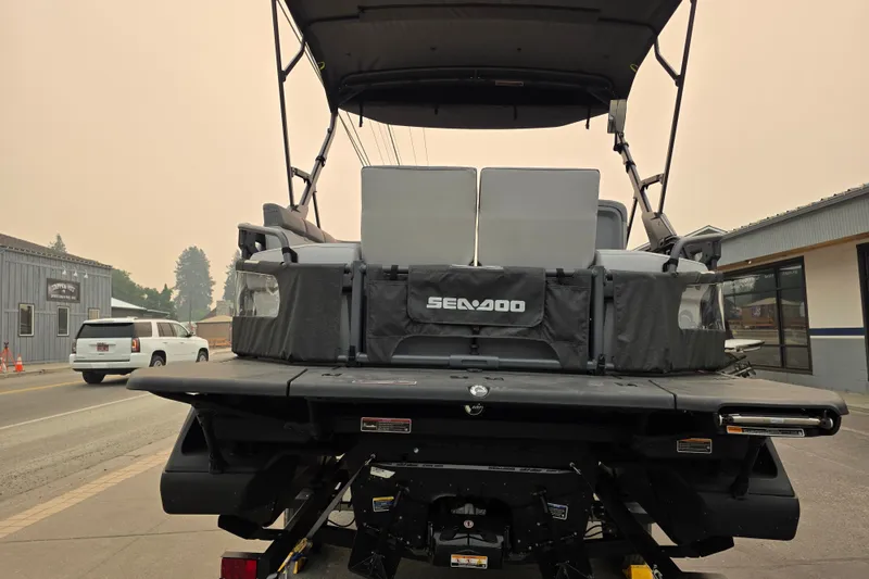 Slide: The Image of 2024 Seadoo Switch Sport boat rear view, parked on a street. - 6