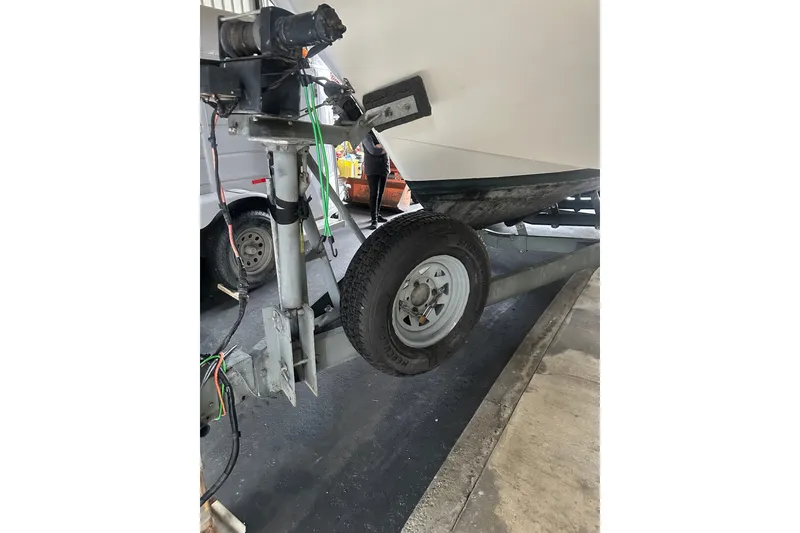 Slide: The Image of Trailer hitch and wheel of a 1999 Skagit Orca 24 boat in a garage setting. - 35