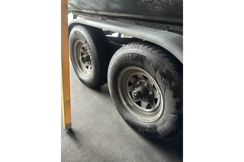 Slide: The Image of Trailer wheels of a 1999 Skagit Orca 24 boat on a concrete surface. - 36