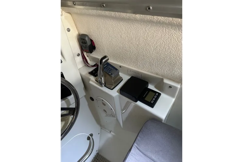 Slide: The Image of Interior controls of a 1999 Skagit Orca 24 boat, featuring steering wheel and electronic devices. - 11