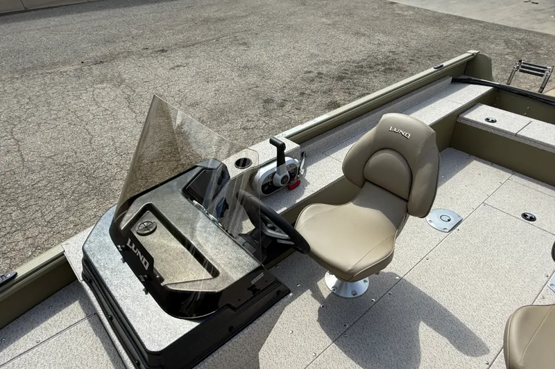 Slide: The Image of 2026 Lund 1875 Alaskan SS boat interior with steering console and beige captain's chair. - 15