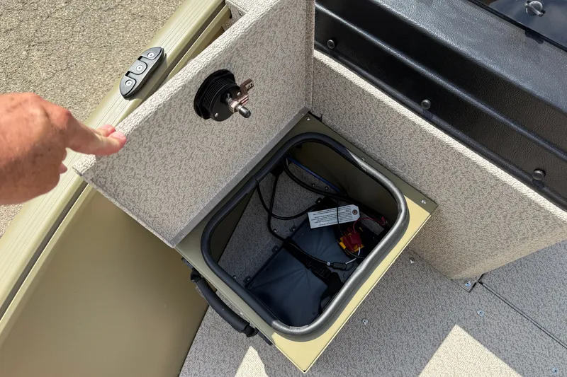 Slide: The Image of 2026 Lund 1875 Alaskan SS boat storage compartment with open lid and visible wiring. - 13