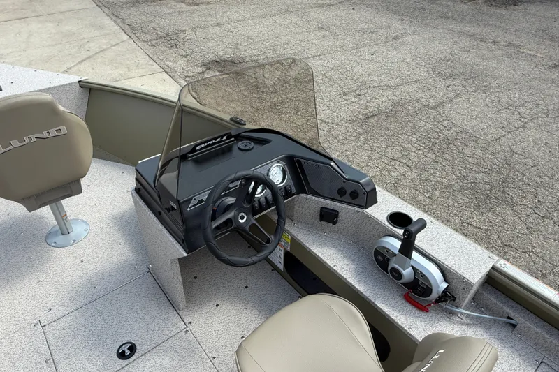 Slide: The Image of 2026 Lund 1875 Alaskan SS boat interior with steering wheel and controls. - 18