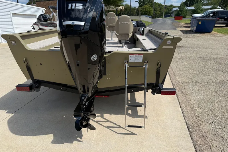 Slide: The Image of 2026 Lund 1875 Alaskan SS boat with powerful outboard motor and ladder, parked on concrete. - 7
