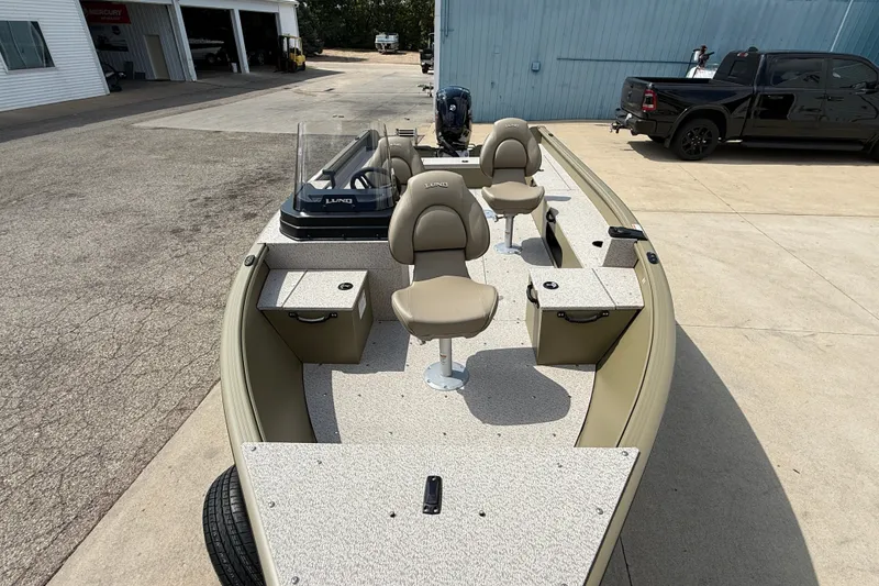 Slide: The Image of 2026 Lund 1875 Alaskan SS boat with seating and storage, parked outdoors. - 9