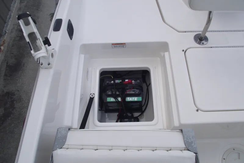 Slide: The Image of 2022 Bayliner Element F21 boat battery compartment with visible wiring and seating area. - 21
