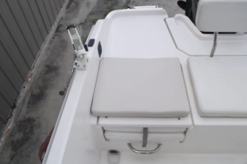 Slide: The Image of 2022 Bayliner Element F21 boat seating area with cushioned seats and rod holder. - 19