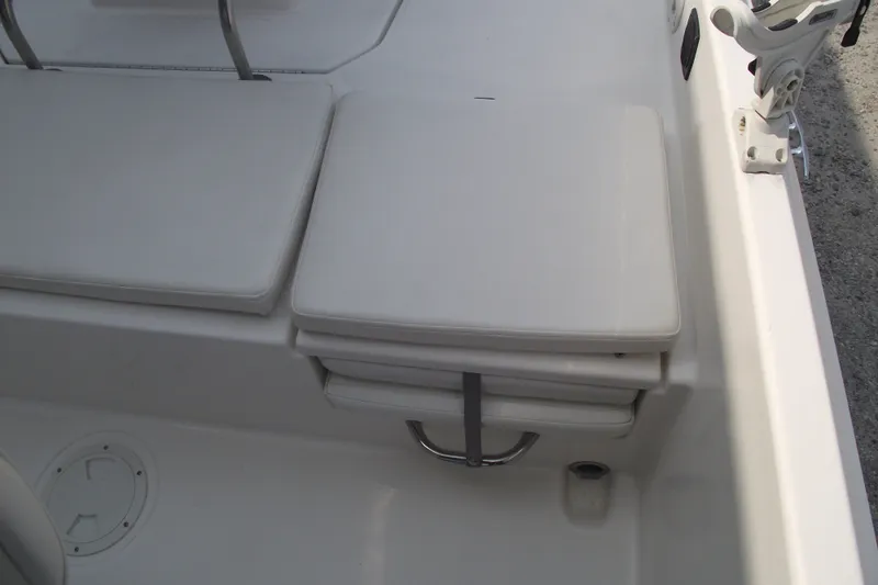 Slide: The Image of 2022 Bayliner Element F21 boat seating area with white cushions and rod holder. - 22