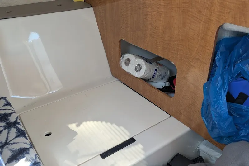 Slide: The Image of Interior of a 2002 Regal 2450 LSC boat with storage compartment and supplies. - 41
