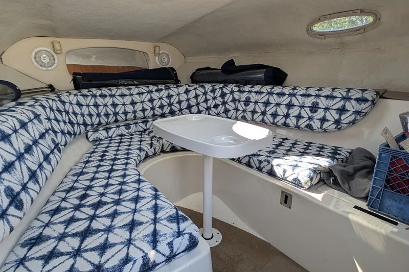 Slide: The Image of 2002 Regal 2450 LSC boat interior with patterned seating and small table. - 38