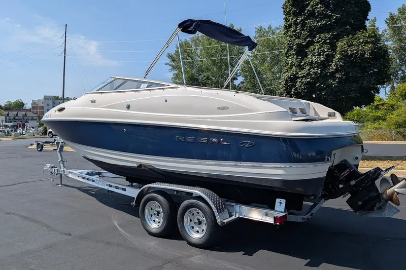 Slide: The Image of 2002 Regal 2450 LSC boat on trailer, parked outdoors on a sunny day. - 2
