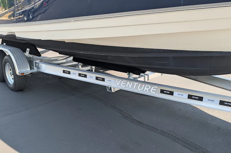 Slide: The Image of 2002 Regal 2450 LSC boat on Venture trailer, parked on asphalt. - 12