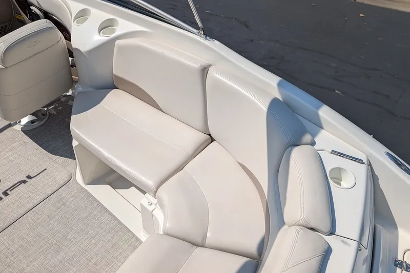 Slide: The Image of 2002 Regal 2450 LSC boat interior with beige seating and cup holders. - 21