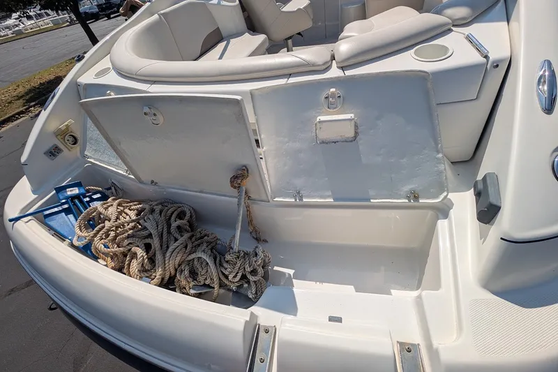 Slide: The Image of 2002 Regal 2450 LSC boat with open storage compartment and coiled ropes. - 14