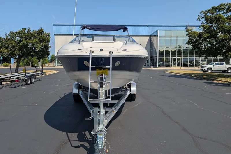 Slide: The Image of 2002 Regal 2450 LSC boat on trailer in parking lot, near modern building. - 8