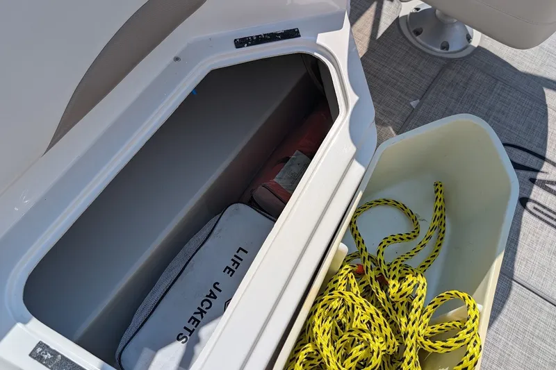 Slide: The Image of Storage compartment on a 2002 Regal 2450 LSC boat with life jackets and yellow rope. - 20