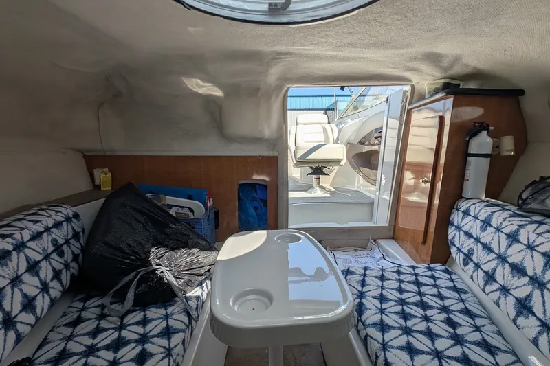 Slide: The Image of Interior of a 2002 Regal 2450 LSC boat with patterned seating and a small table. - 40