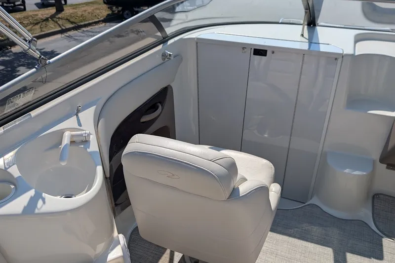 Slide: The Image of Interior of a 2002 Regal 2450 LSC boat featuring a white captain's chair and sink. - 26
