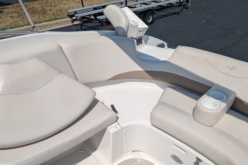 Slide: The Image of 2002 Regal 2450 LSC boat interior with beige seating and cup holders. - 23