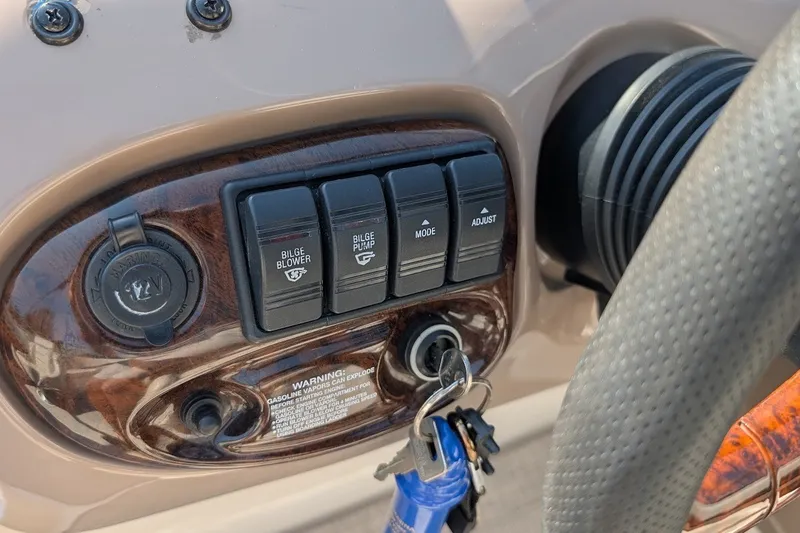 Slide: The Image of Control panel of a 2002 Regal 2450 LSC boat with switches and ignition keys. - 34
