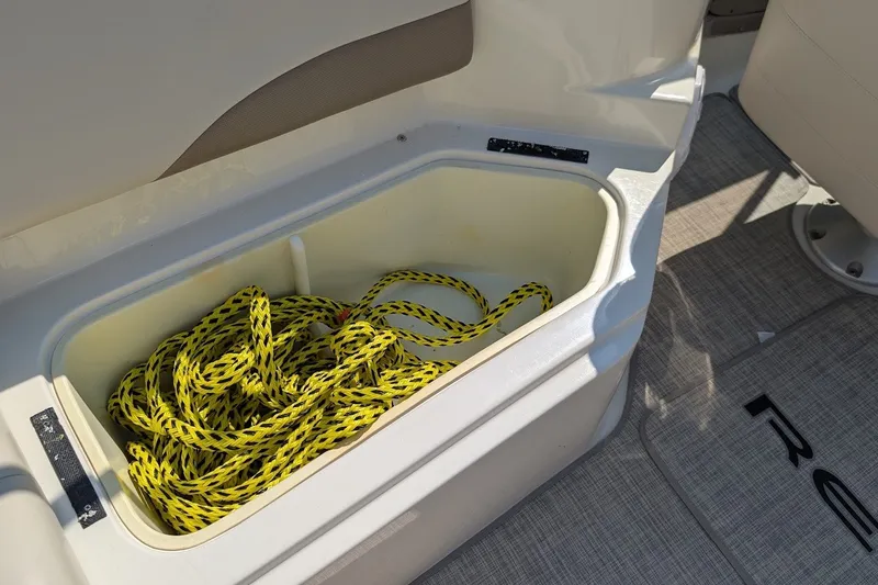 Slide: The Image of Storage compartment with yellow rope on a 2002 Regal 2450 LSC boat. - 19