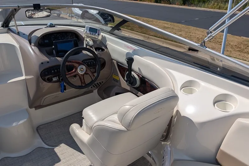 Slide: The Image of Interior of a 2002 Regal 2450 LSC boat, featuring steering wheel and dashboard controls. - 30
