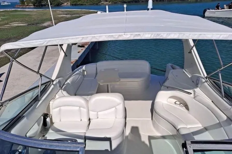 Slide: The Image of 2001 Wellcraft 3300 Martinique boat interior with white seating and canopy, docked by the water. - 30