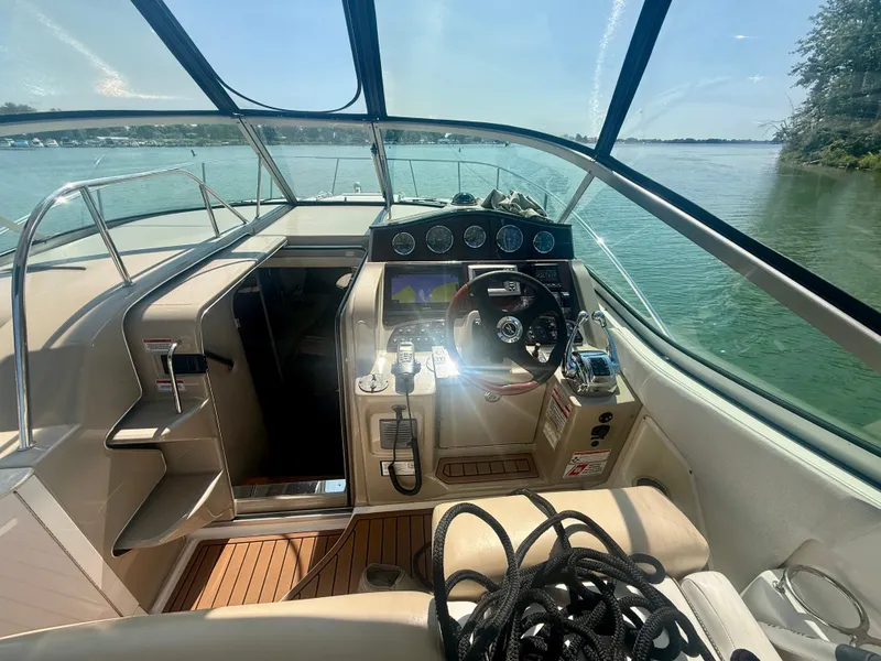 Slide: The Image of The cockpit of a 2009 Sea Ray Sundancer 310 with modern instruments and a clear view of the water. - 8