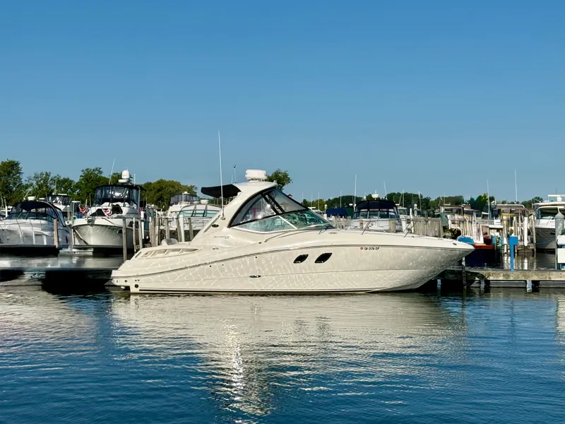 Slide: The Image of The 2009 Sea Ray Sundancer 310 is docked in a marina on a sunny day. - 23