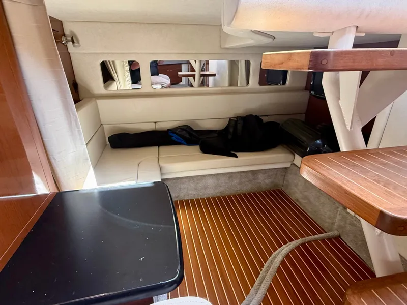 Slide: The Image of Interior of a 2009 Sea Ray Sundancer 310 with wood flooring and white upholstery. - 18